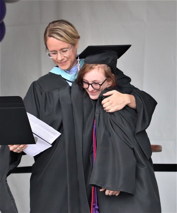 An Arts and Technology High School graduate gets a hug from principal Becca Shook.
